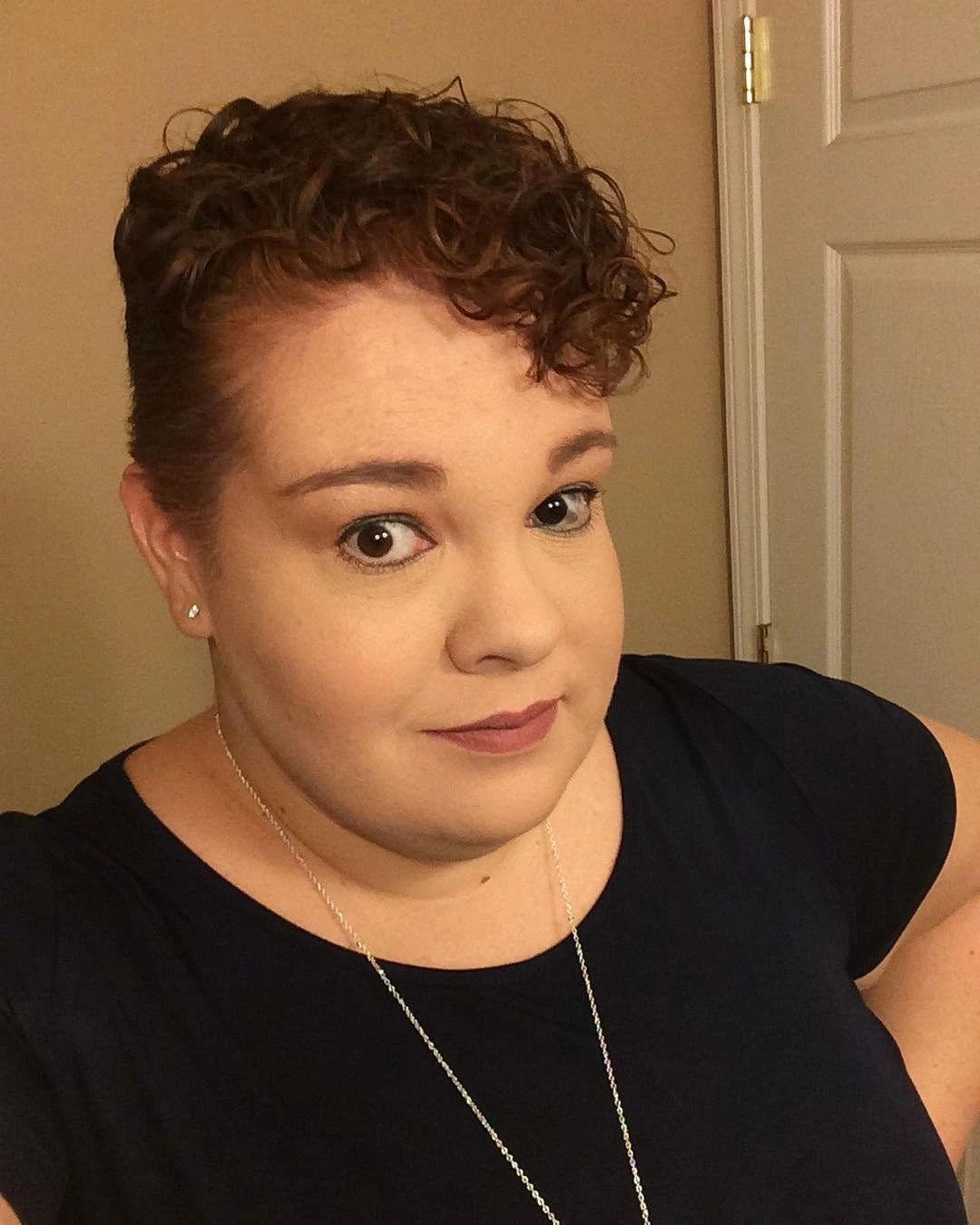 Short curly pixie with close sides and forward curls
