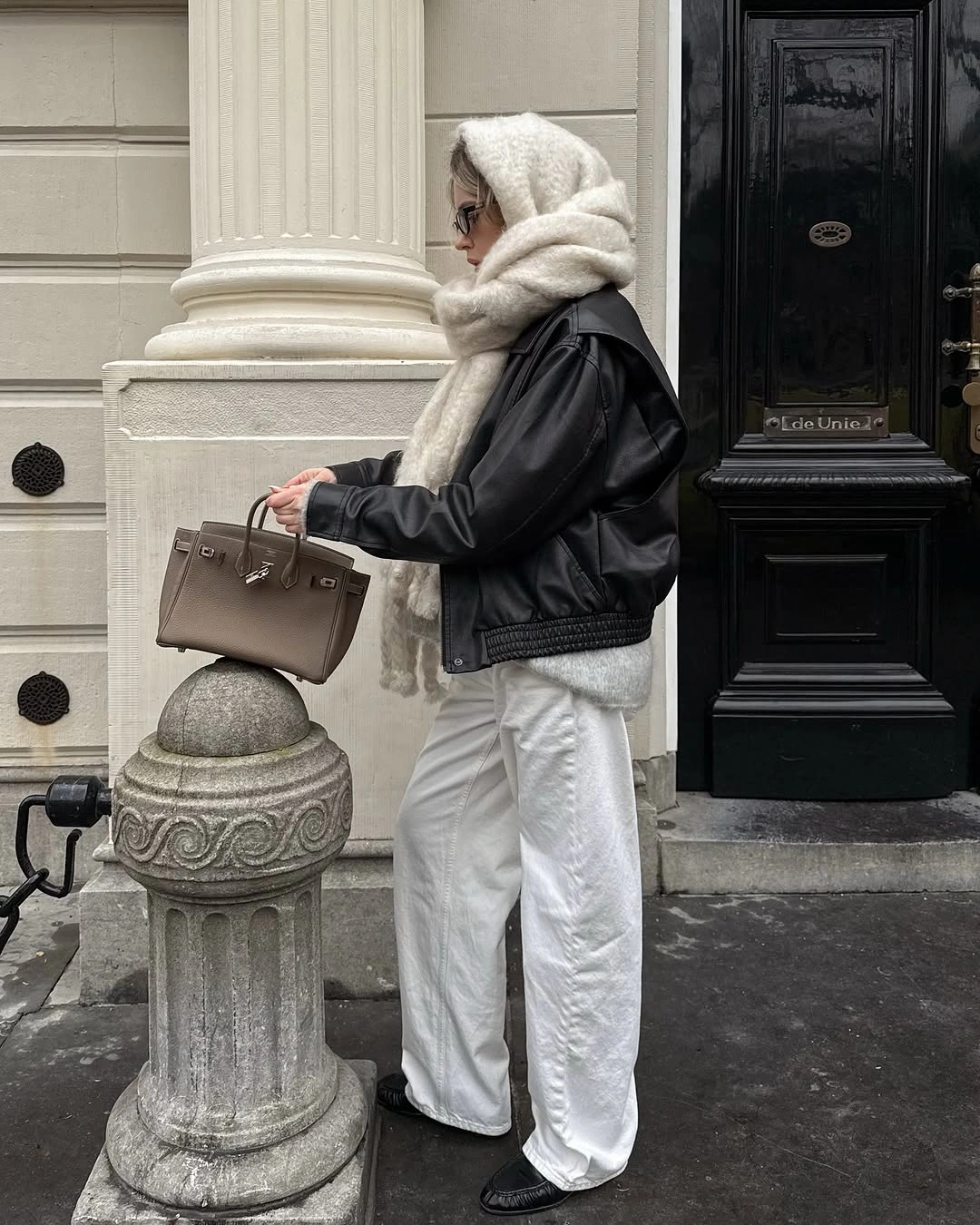 Person in black cropped jacket, cream scarf and white trousers