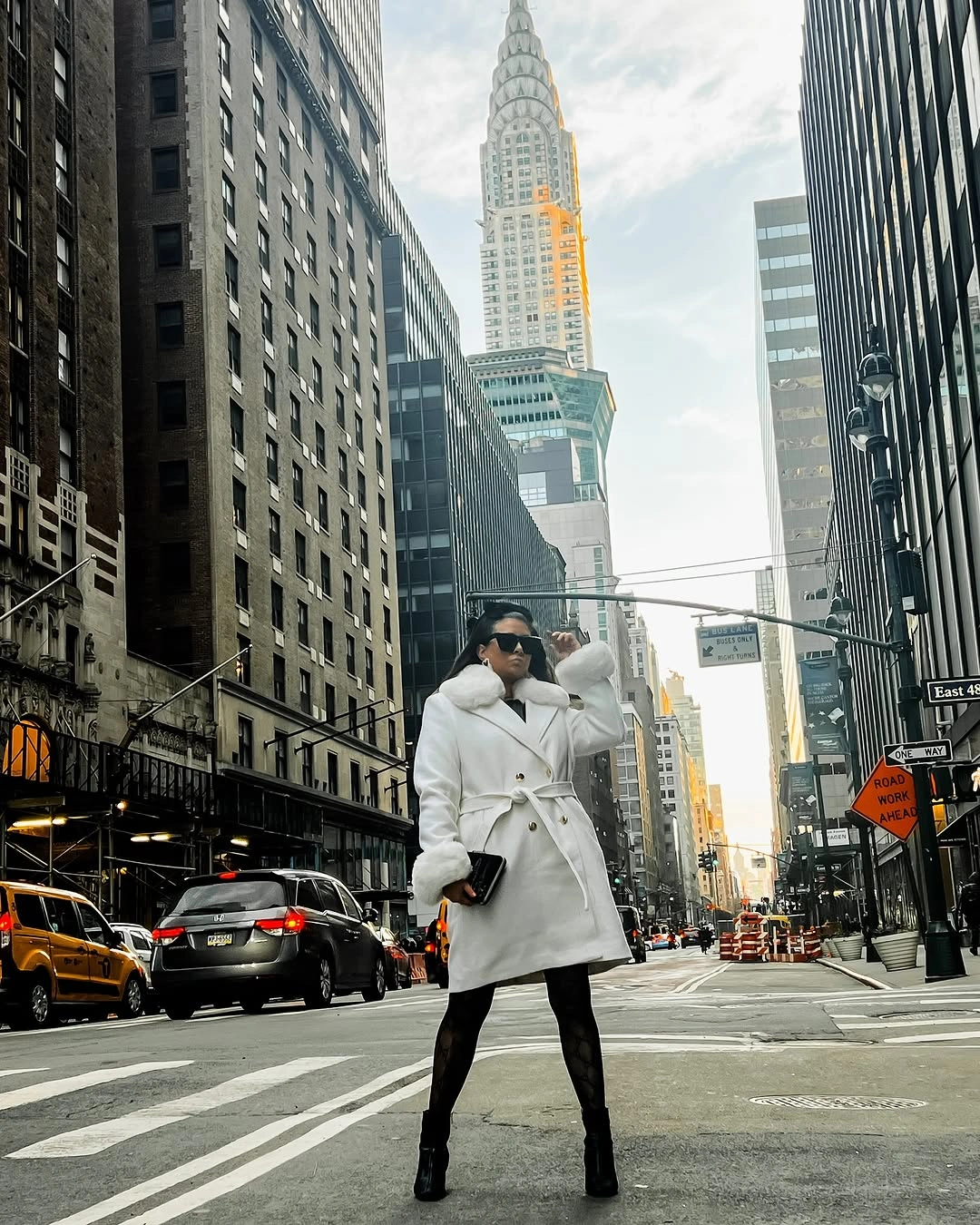 Person in white belted coat and tall black boots on street