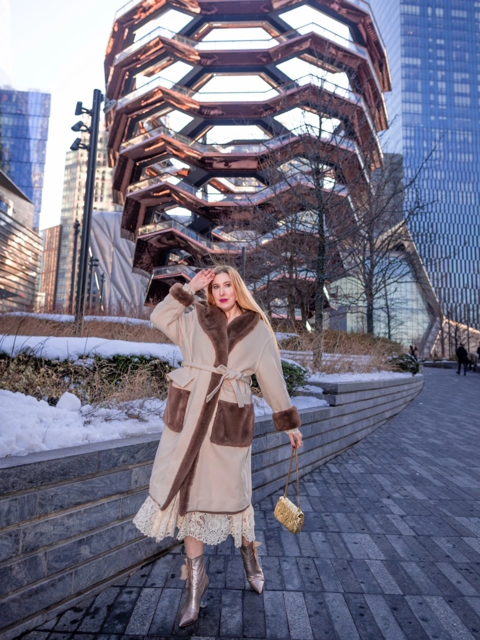 Person in cream brown coat, lace-trim hem and metallic boots