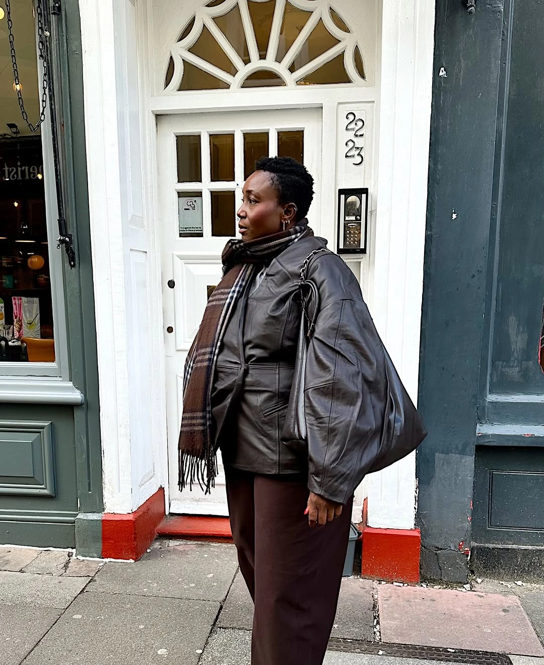 Gray leather-like jacket with brown scarf and shoulder bag
