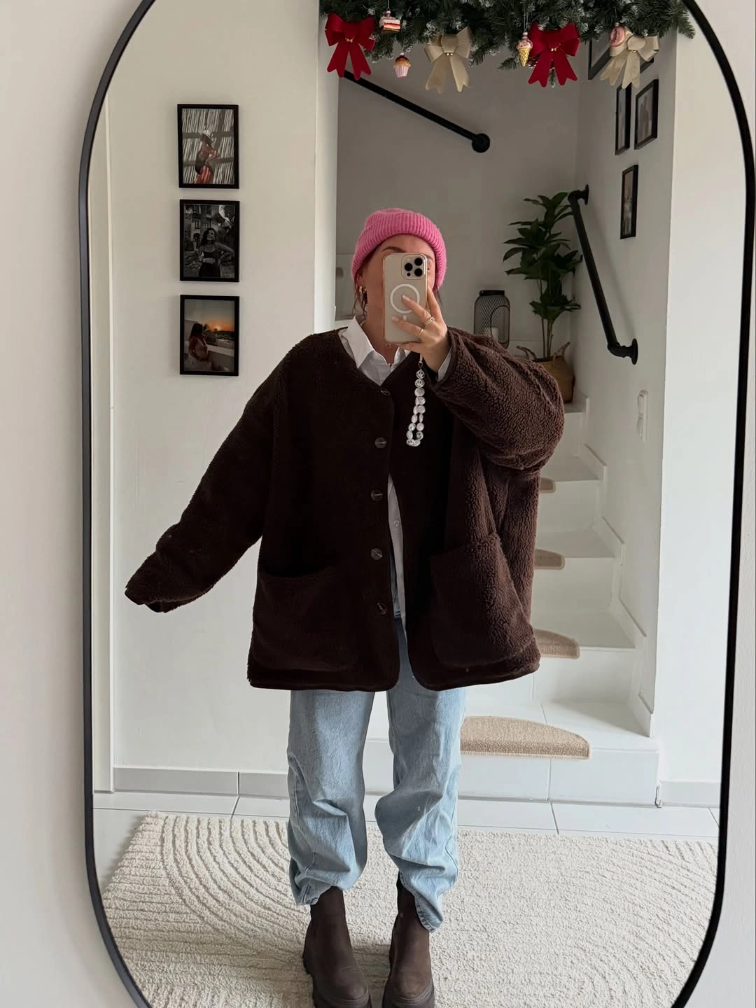 Brown textured jacket with pink beanie and light jeans