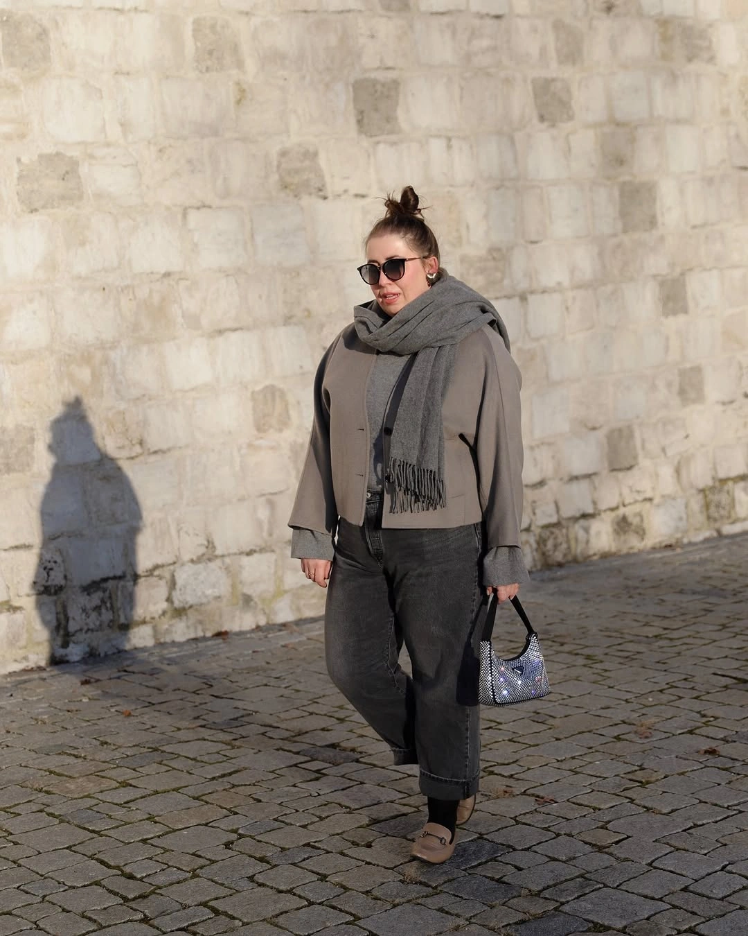 Gray scarf with short taupe layer and cropped dark trousers