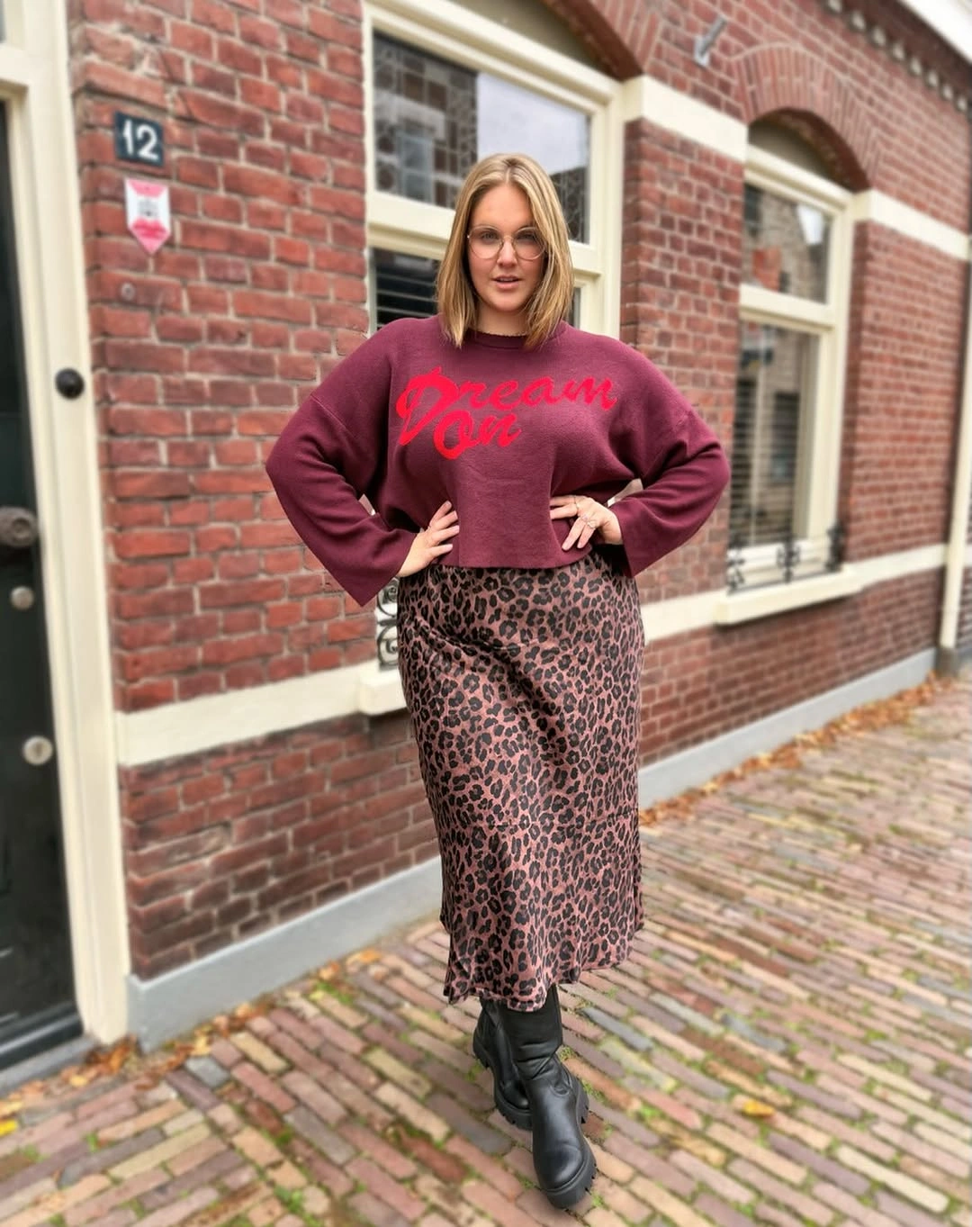 Cropped burgundy sweatshirt with leopard midi skirt and boots