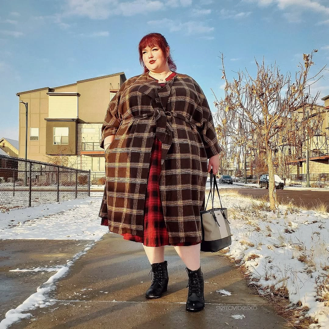 Brown plaid coat over red plaid skirt with black boots