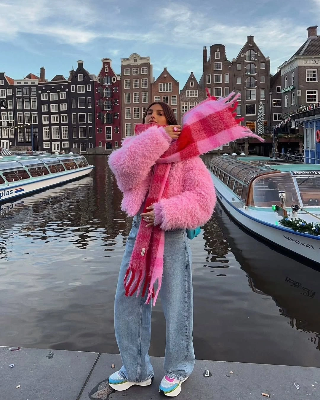 Fluffy pink coat with red scarf and light wide jeans