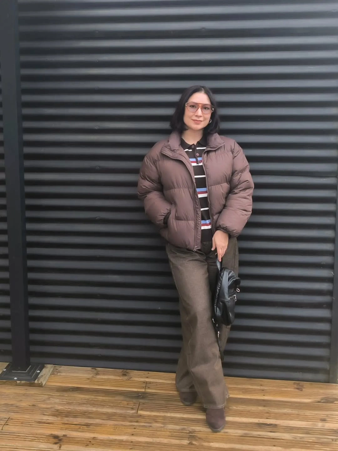 Brown puffer with striped top, brown trousers and black bag