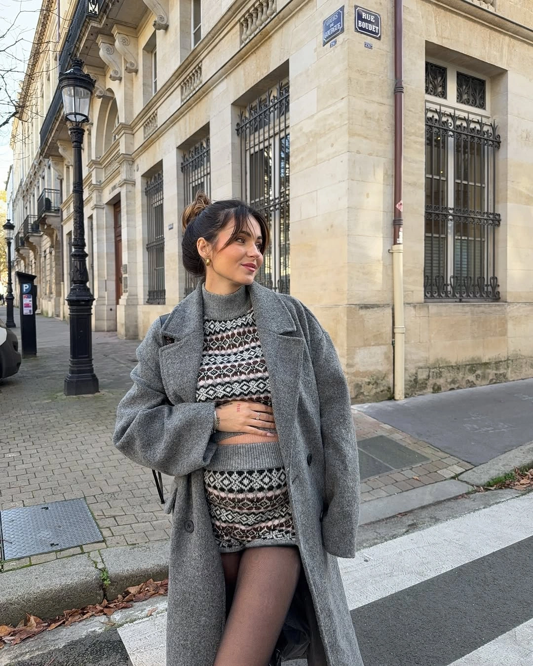 Gray coat over patterned knit top and dark tights