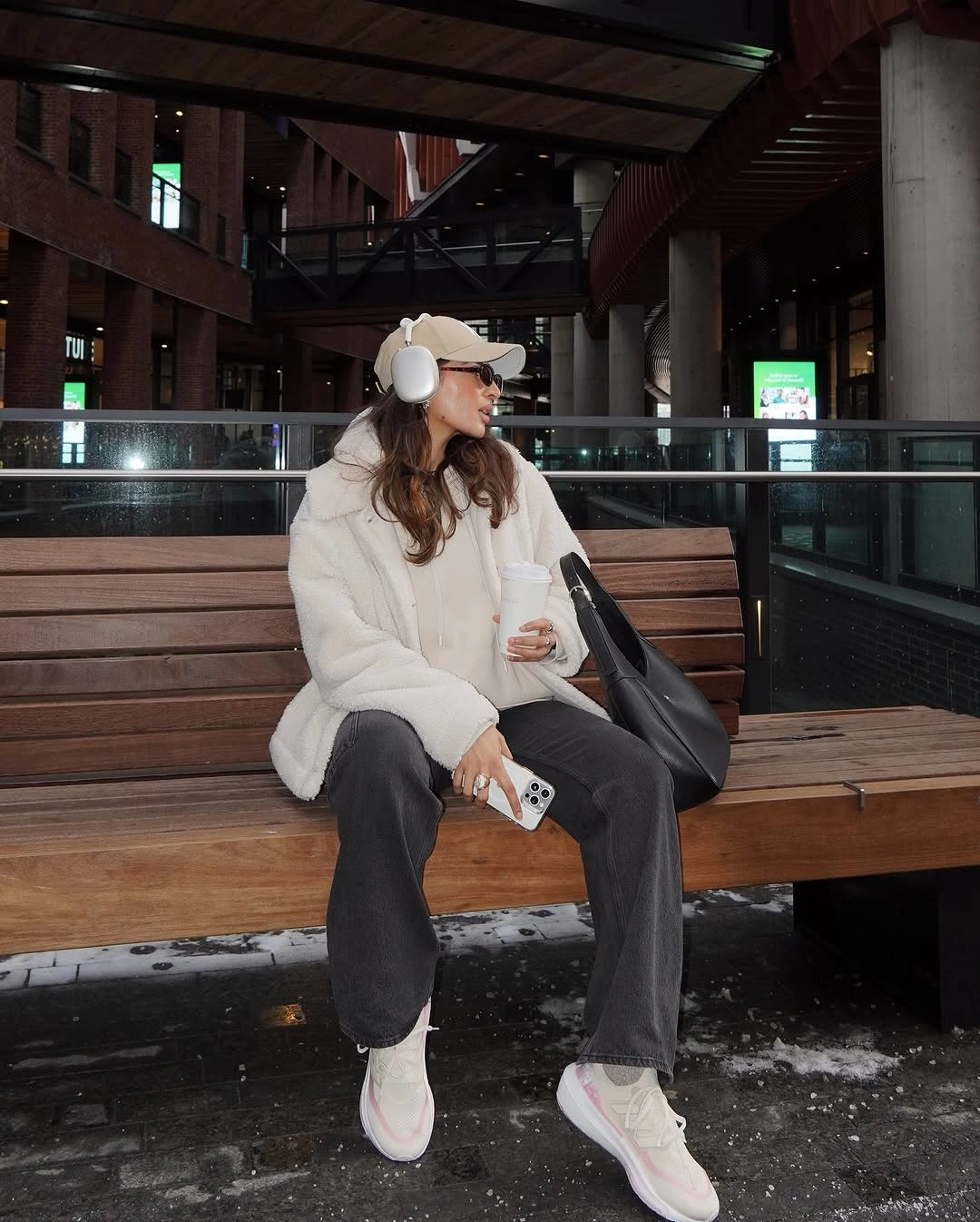 White fuzzy coat with cap, headphones and dark wide trousers