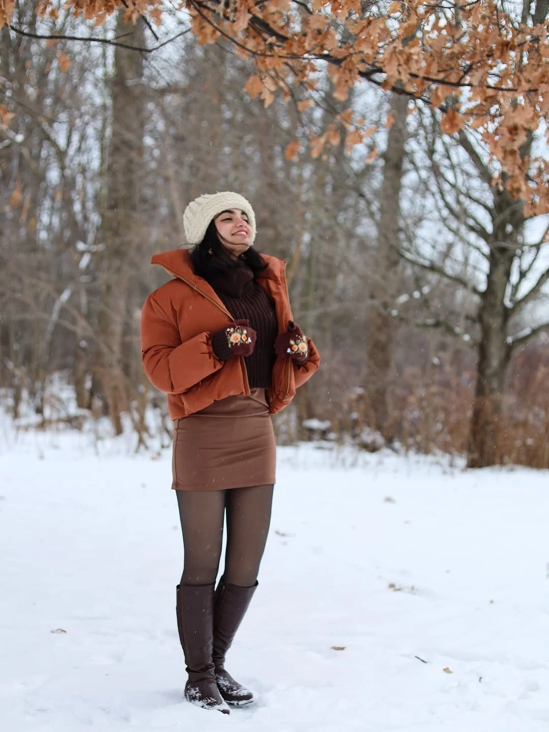 Brown cropped jacket and skirt with tall boots and cream beanie