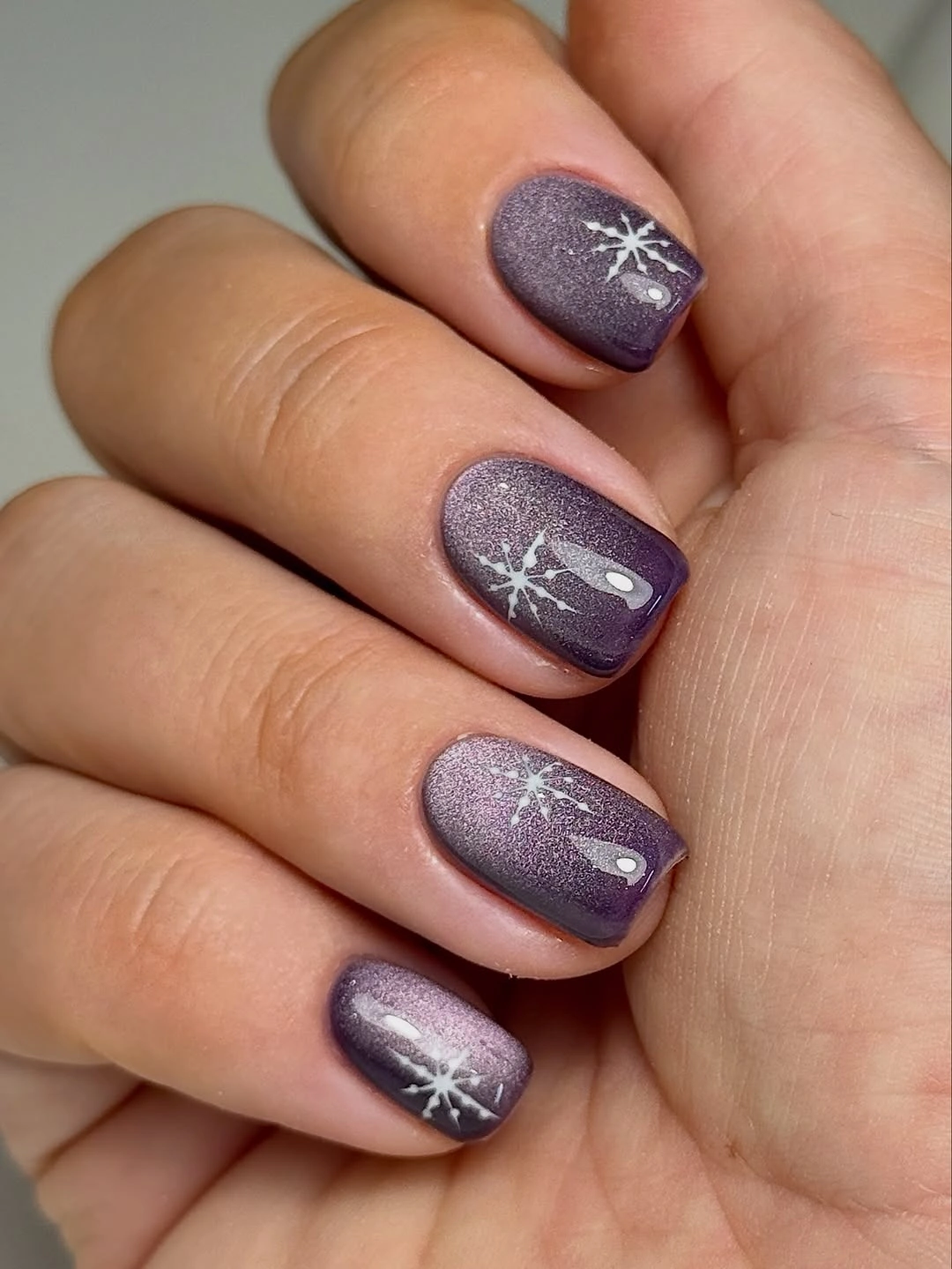 Short purple square nails with reflective shimmer and snowflakes