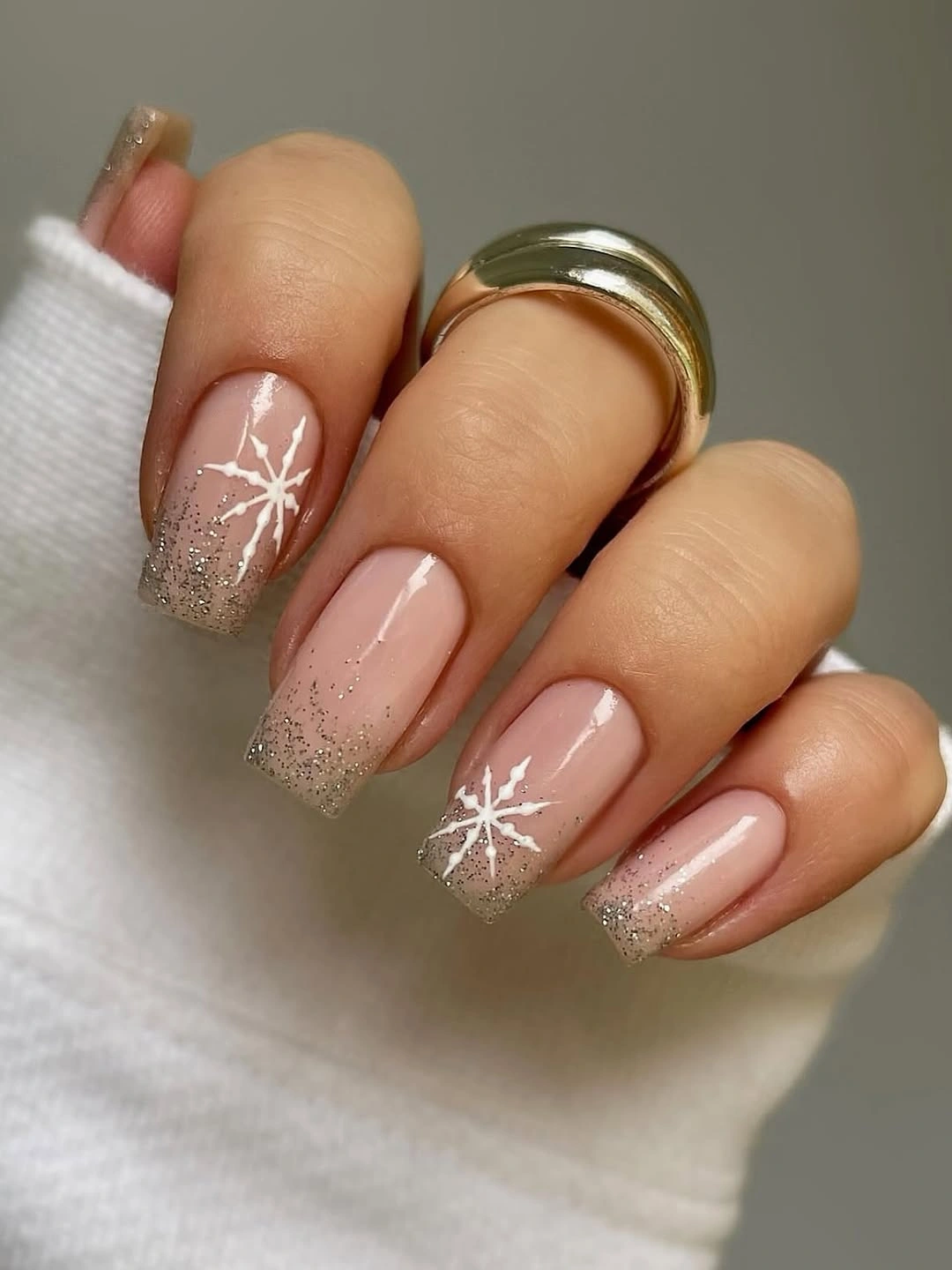 Nude square nails with glitter tips and white snowflakes