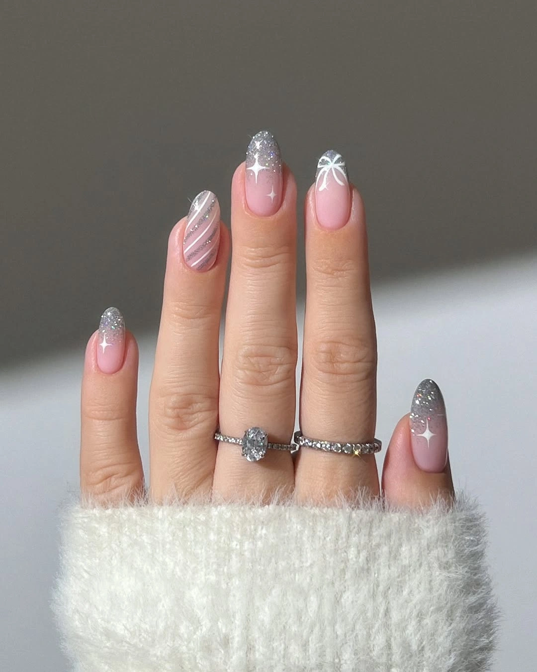Almond nails with silver glitter fades and white snowflakes